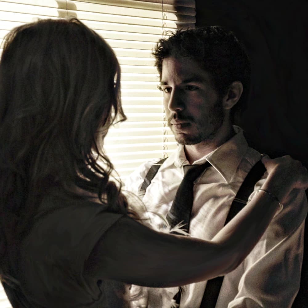 Gabriel DiMilo in a noir scene by the window blinds
